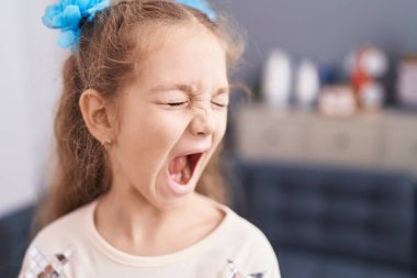 Adorable caucasian girl screaming at home