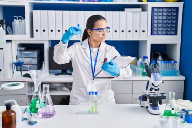 Laboratuvarda test tüpü tutan genç İspanyol bilim kadını.