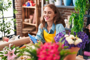 Çiçekçiye dokunarak gülen güzel İspanyol kadın çiçekçi.