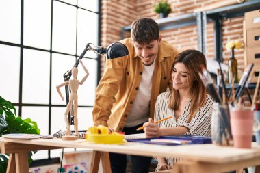 Mand and woman artist couple drawing on notebook at art studio