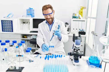 Orta yaşlı, labaratuarda çalışan bilim adamı üniforması giyen bir İspanyol.