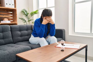Young hispanic woman crying having psychology session at clinic