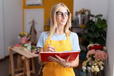 Çiçekçi dükkanında kendine güvenen genç sarışın bir çiçekçi.