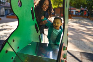 Mother and son playing on slide at park