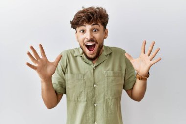 Young arab doctor man standing over isolated background celebrating crazy and amazed for success with arms raised and open eyes screaming excited. winner concept 