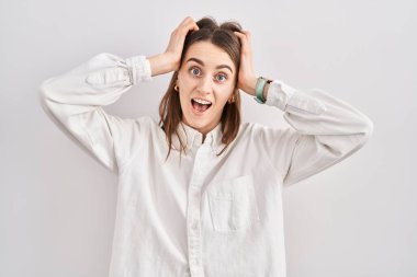 Kafkasyalı genç bir kadın izole edilmiş arka planda duruyor. Deli ve korkmuş, elleri başının üstünde, korkmuş ve ağzı açık bir şekilde şok geçirmekten korkan. 