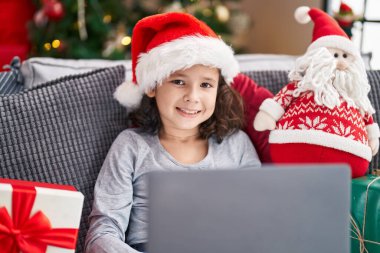 Evdeki Noel ağacının yanında dizüstü bilgisayar kullanan sevimli Çinli kız.