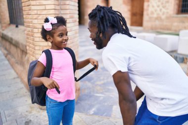 Father and daughter standing together speaking at school