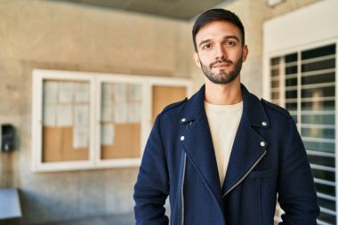 Sokakta ciddi bir ifadeyle duran İspanyol genç adam.