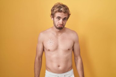 Caucasian man standing shirtless wearing sun screen depressed and worry for distress, crying angry and afraid. sad expression. 
