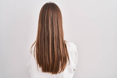 Kafkasyalı genç bir kadın izole edilmiş arka planda dikilip kollarını kavuşturup arkasına bakıyor. 