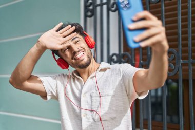 Genç Arap adam gülümsüyor. Sokaktan video çağrısı aldığından emin.