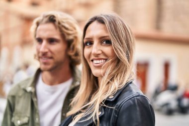 Erkek ve kadın bir arada durarak gülümsüyor.