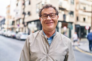 Middle age man smiling confident walking at street