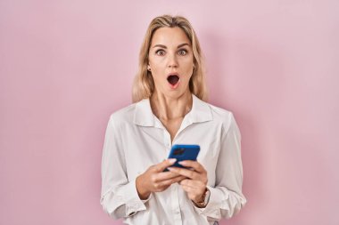 Kafkasyalı genç bir kadın akıllı telefon kullanıyor. Mesaj yazıyor. Korkmuş ve şok olmuş bir halde.. 