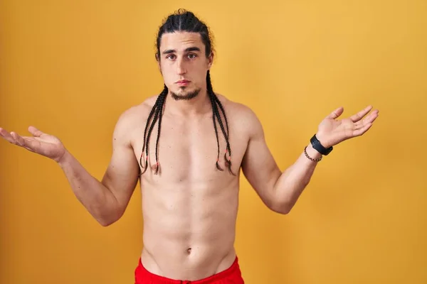Hispanic Man Long Hair Standing Shirtless Yellow Background Clueless Confused — 图库照片