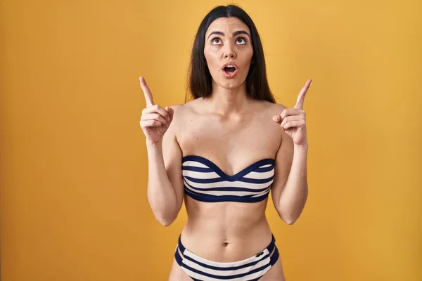 Jeune Femme Brune Portant Bikini Sur Fond Jaune Étonné Surpris — Photo