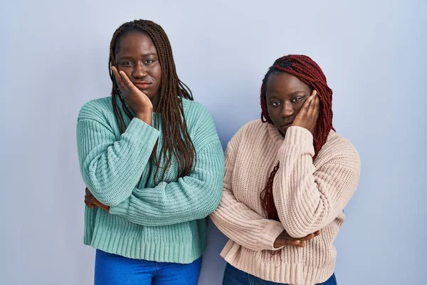 Twee Afrikaanse Vrouw Staan Blauwe Achtergrond Denken Kijken Moe Verveeld — Stockfoto