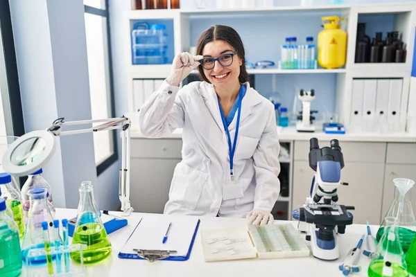 研究室で働く科学者の制服を着た若いヒスパニック系女性 — ストック写真