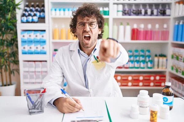 Hispanic Young Man Working Pharmacy Drugstore Pointing Displeased Frustrated Camera — Fotografia de Stock