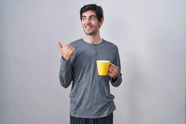 Mladý Hispánec Pyžamu Pije Šálek Kávy Usmívá Šťastnou Tváří Ukazuje — Stock fotografie