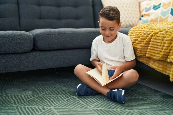 愛らしいヒスパニック系の幼児読書本座っています上の床にホーム — ストック写真