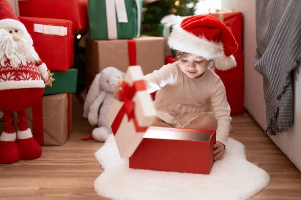 可爱的女孩在家里坐在圣诞树旁拆礼物 — 图库照片