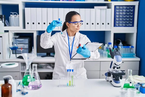 Laboratuvarda test tüpü tutan genç İspanyol bilim kadını.