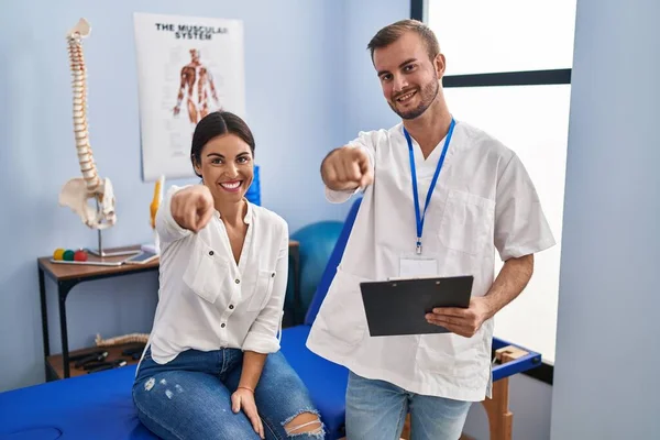 Young Hispanic Woman Physiotherapist Appointment Pointing You Camera Fingers Smiling — Stockfoto