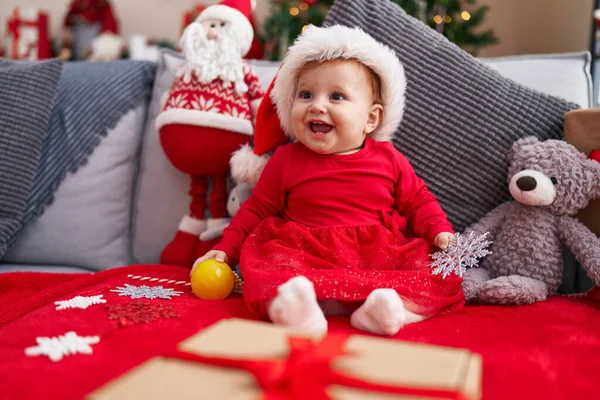 可爱的红头发幼儿 戴着圣诞礼帽坐在家里的沙发上 — 图库照片