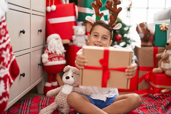 Adorable Niño Hispano Sosteniendo Regalo Navidad Sentado Suelo Casa —  Fotos de Stock