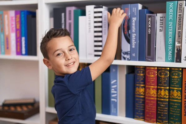 Adorable Hispanic Toddler Smiling Confident Holding Book Shelving Library School — ストック写真