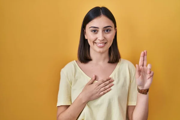 Hispanic Girl Wearing Casual Shirt Yellow Background Smiling Swearing Hand — Zdjęcie stockowe