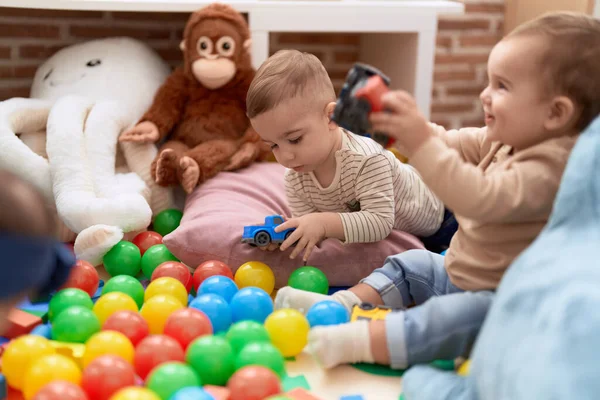 Anaokulunun Zemininde Oturan Iki Küçük Bebek Top Arabayla Oynuyorlar — Stok fotoğraf