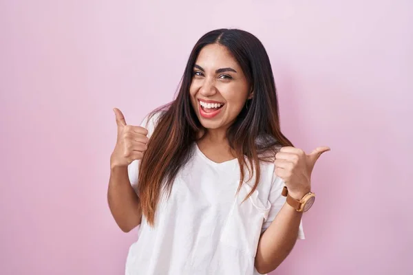 ピンクの背景の成功の印の上に立つ若いアラブ人の女性は手で肯定的なジェスチャーをし 親指を笑顔と幸せ 陽気な表情と勝者のジェスチャー — ストック写真