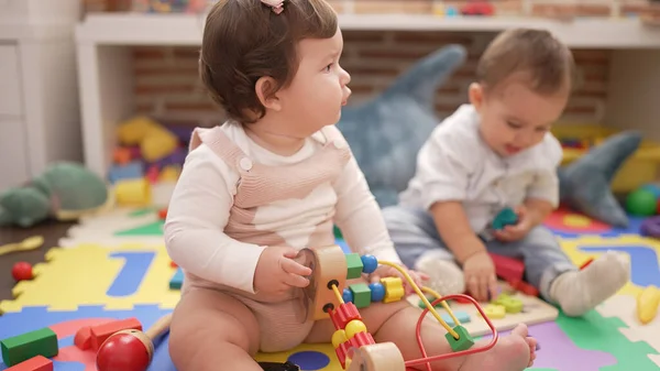 Dwa Maluchy Bawiące Się Zabawkami Siedzącymi Podłodze Przedszkolu — Zdjęcie stockowe