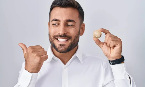 Handsome Hispanic Man Holding Polkadot Cryptocurrency Coin Pointing Thumb Side — Stock Photo, Image