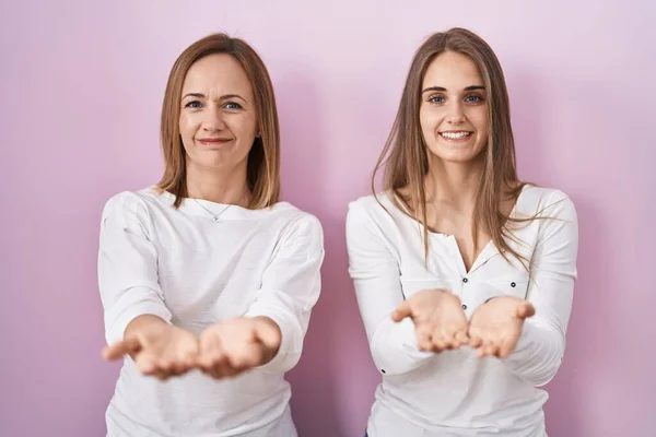 Middle Age Mother Young Daughter Standing Pink Background Smiling Hands — Stock Photo, Image