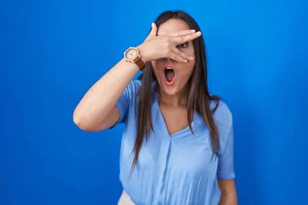 Young Brunette Woman Standing Blue Background Peeking Shock Covering Face — Stock Photo, Image
