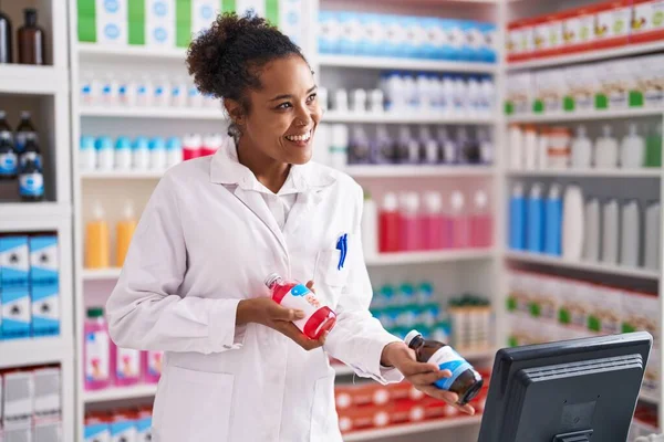 Afrikansk Amerikansk Kvinna Farmaceut Med Hjälp Dator Som Håller Läkemedelsflaskor — Stockfoto