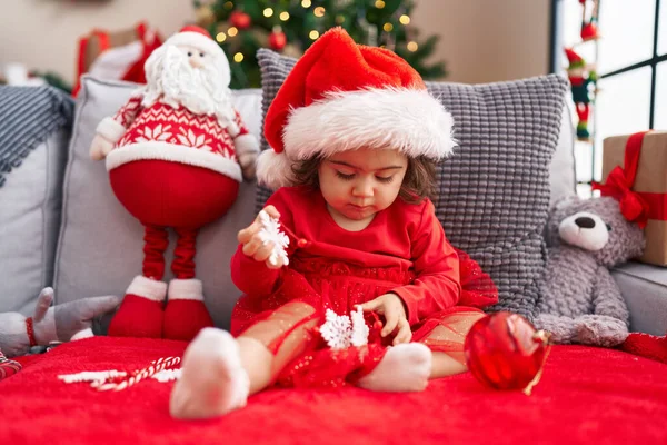 愛らしいHispanic女の子座っています上のソファによってクリスマスツリーホーム — ストック写真