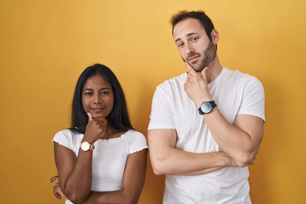 Interracial Couple Standing Yellow Background Looking Confident Camera Smiling Crossed — ストック写真