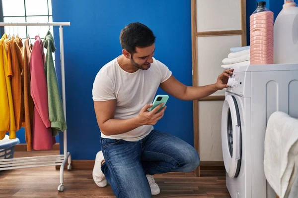Young Hispanic Man Using Smartphone Turning Washing Machine Laundry Room — Stock Photo, Image
