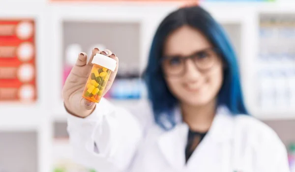 若い白人女性薬剤師笑顔自信を持って保持薬瓶に薬局 — ストック写真