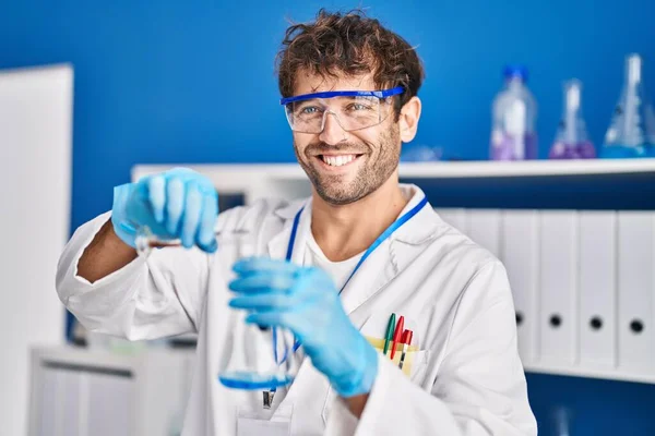 Young Man Scientist Smiling Confident Pouring Liquid Test Tube Laboratory — Stockfoto
