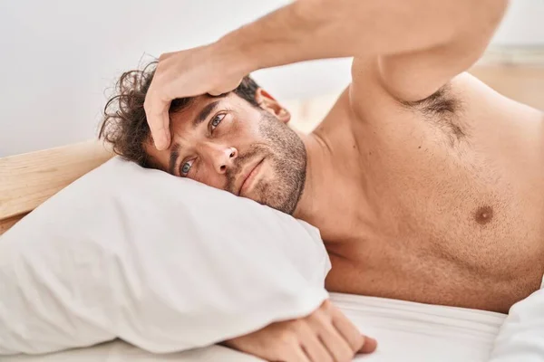 Young man lying on bed suffering for headache at bedroom