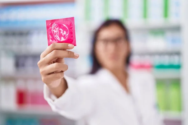 Young Beautiful Hispanic Woman Pharmacist Smiling Confident Holding Condom Pharmacy — Stock Photo, Image