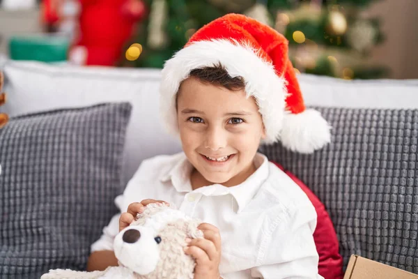 Adorable Niño Hispano Abrazando Oso Peluche Sentado Sofá Por Árbol —  Fotos de Stock