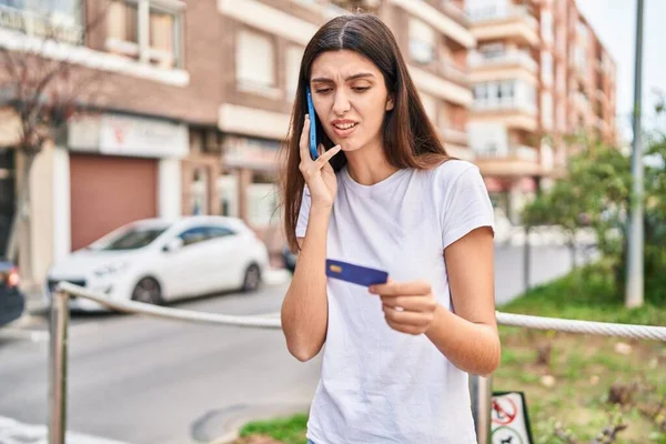 年轻美丽的惊慌失措的女人在街上用智能手机和信用卡 — 图库照片