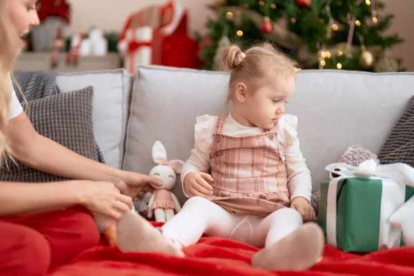 可爱的高加索女孩坐在家里的圣诞树旁的沙发上 — 图库照片